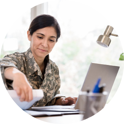 A woman in army attire working at a desk