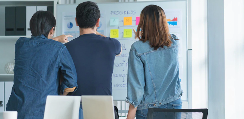 Coworkers collaborating on a white board