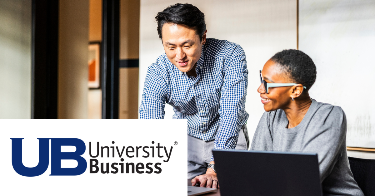 Two faculty members conversing over a laptop with the "University Business" logo.
