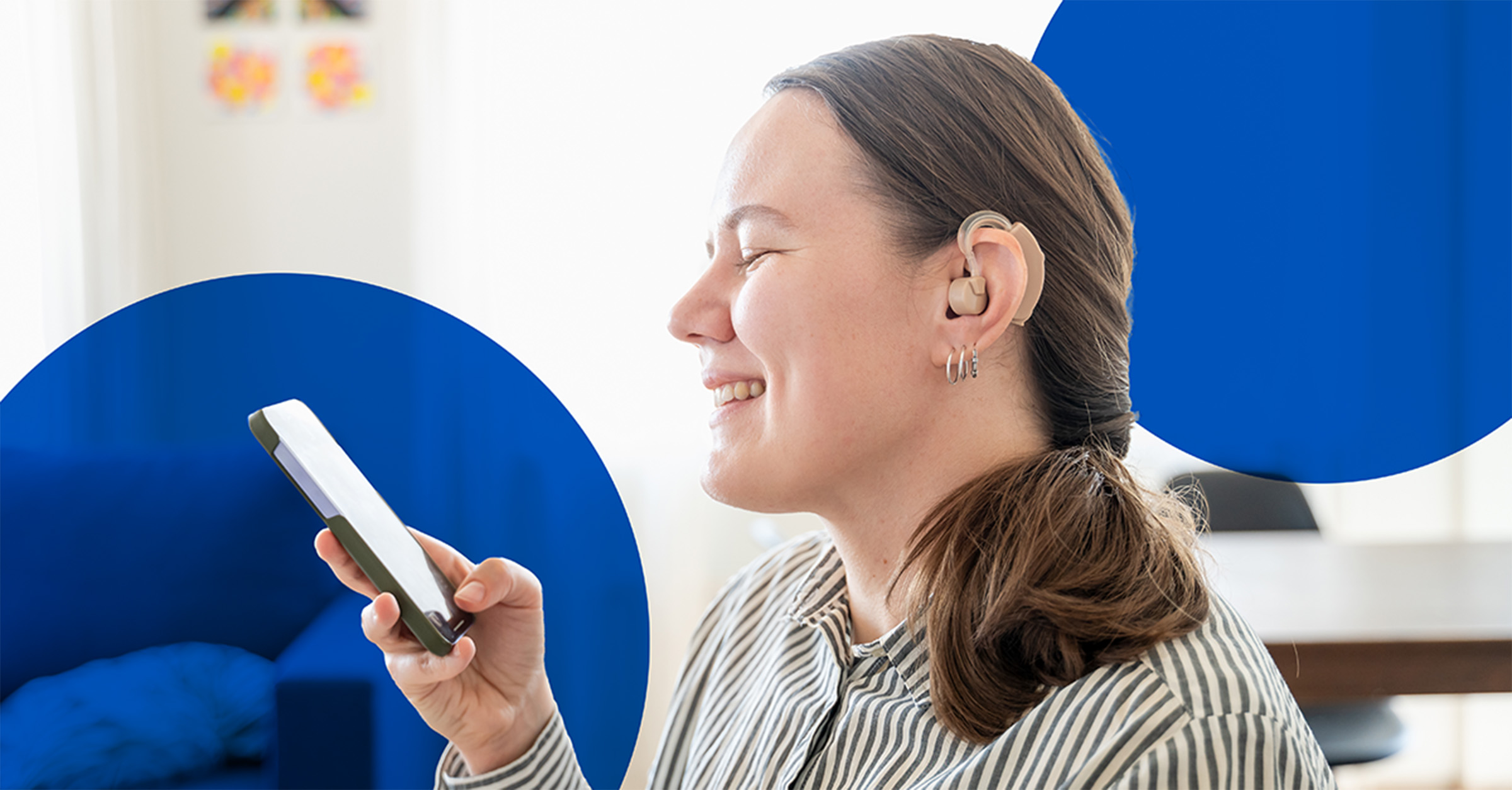A woman with a hearing device using her phone