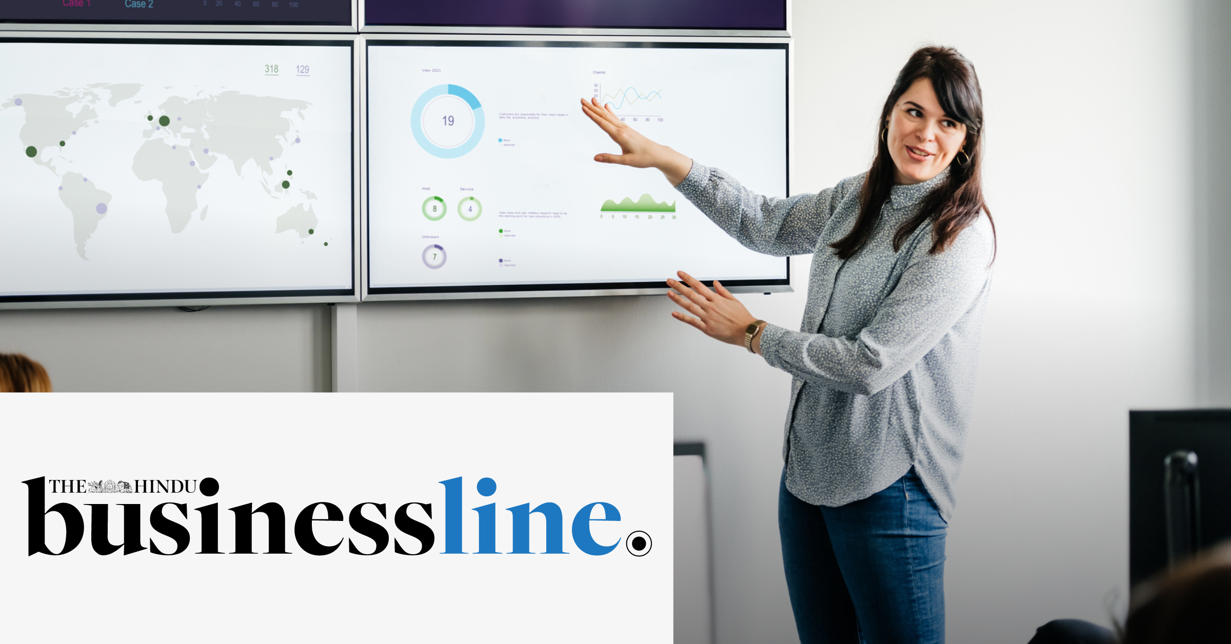 Image of a woman presenting a report to an audience using some screens. On the lower left corner of the image is placed The Hindu Business Line logo.