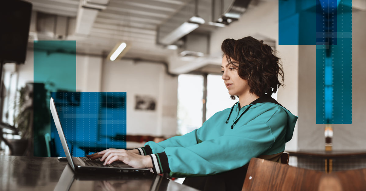 Photo of a woman working at a laptop in a shared workspace