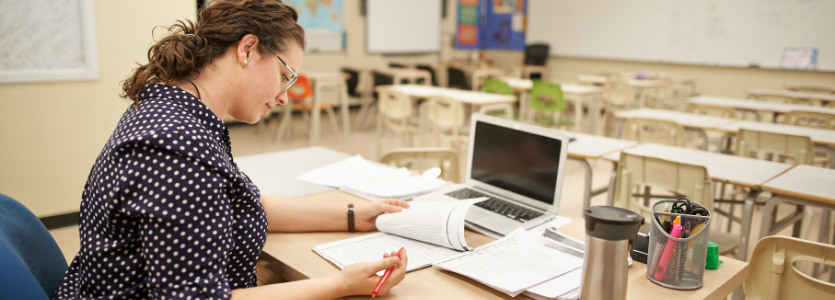 Photo of a woman reviewing papers at her desk