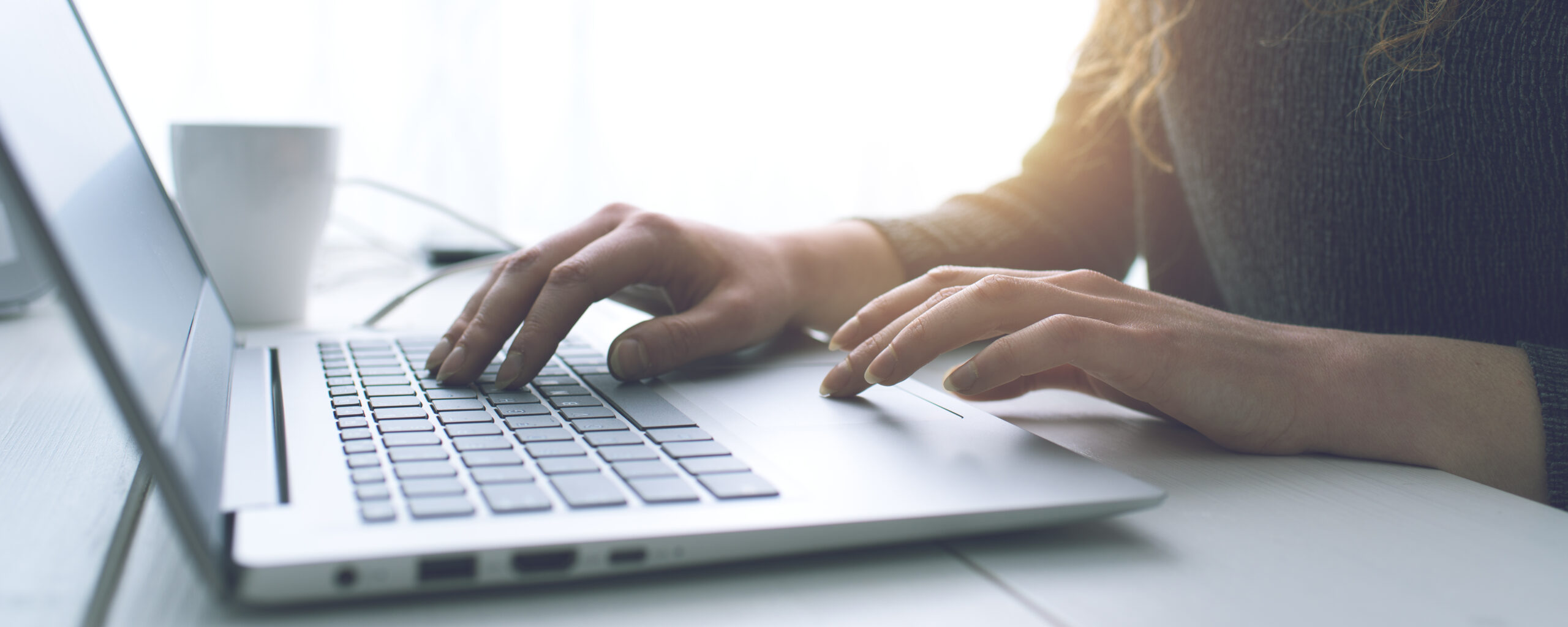 Close up photo of hands working at a laptop
