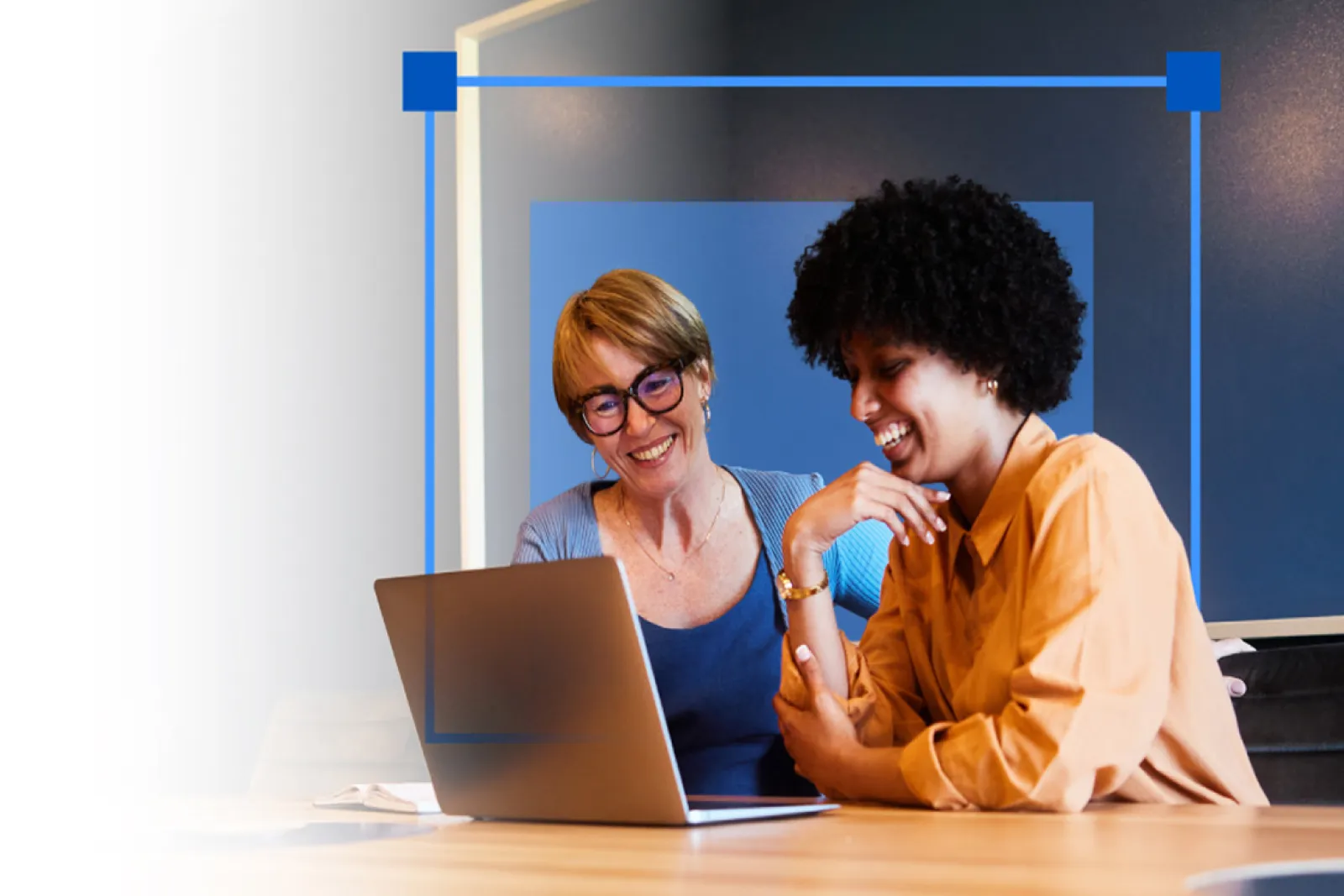 Photo of two women working at a laptop